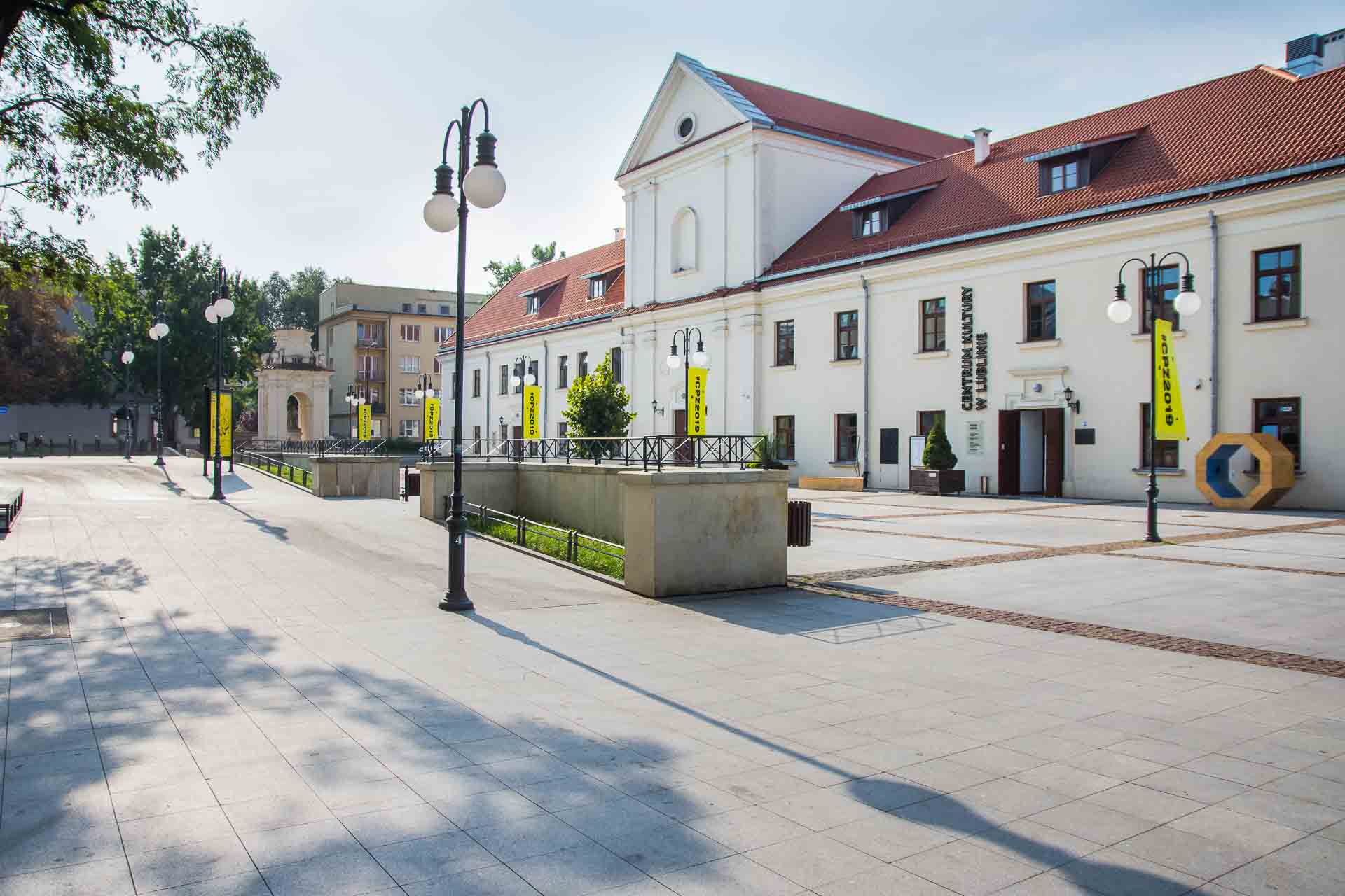 Plac przed Centrum Kultury, nawierzchnia równa z elementami wypukłymi, pokazana droga do głównego wejścia bez barier architektonicznych