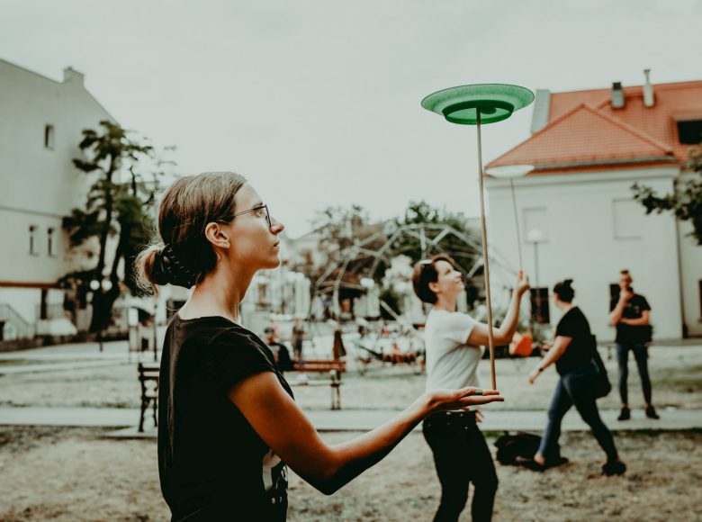 Zdjęcie. Podczas warsztatów kobieta żongluje talerzem na kiju.