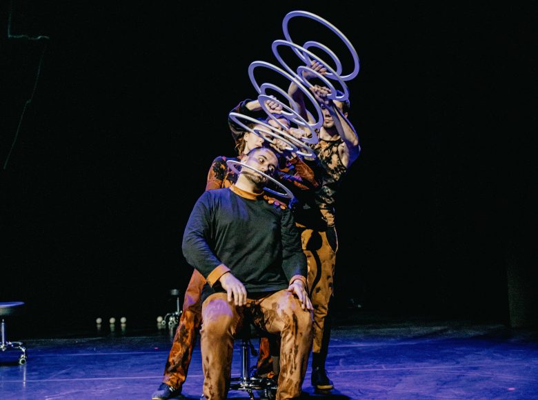 Zdjęcie przedstawia grupę kuglarzy na scenie podczas występu