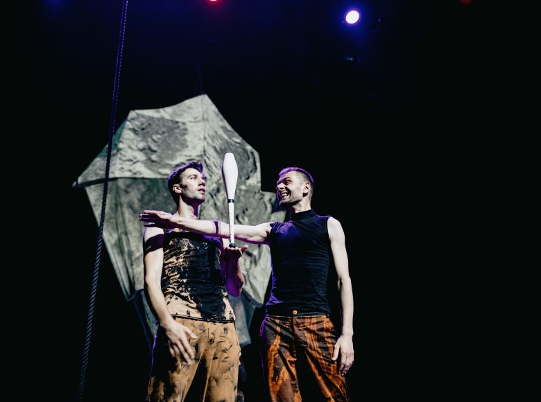 Zdjęcie przedstawia dwóch kuglarzy stojących na scenie