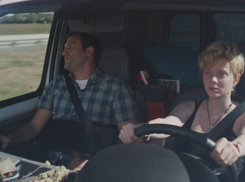 [ Kadr z filmu. Wnętrze samochodu. Za kierownicą młoda dziewczyna, obok niej starszy mężczyzna patrzy za okno. ]