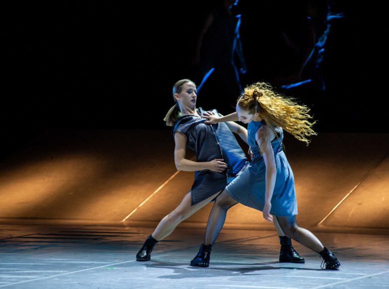 Na scenie dwie tancerki tańca współczesnego w dynamicznym układzie tanecznym.