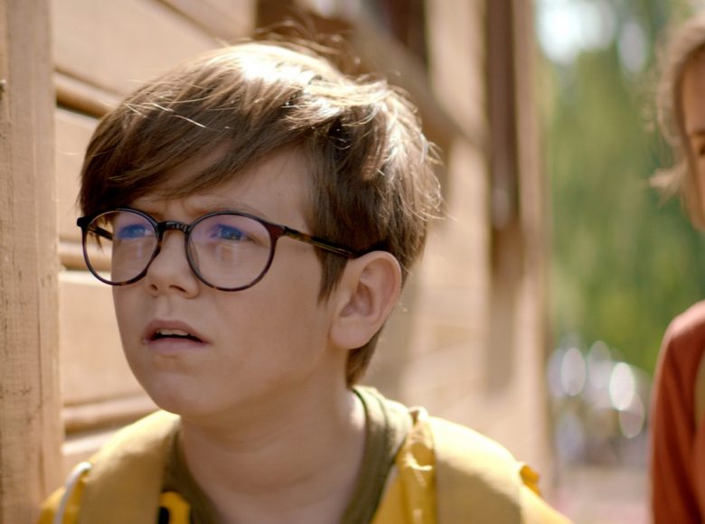 kadr z filmu. Przedstawia chłopca w okularach i dziewczynkę patrzących z zaciekawieniem w jednym kierunku