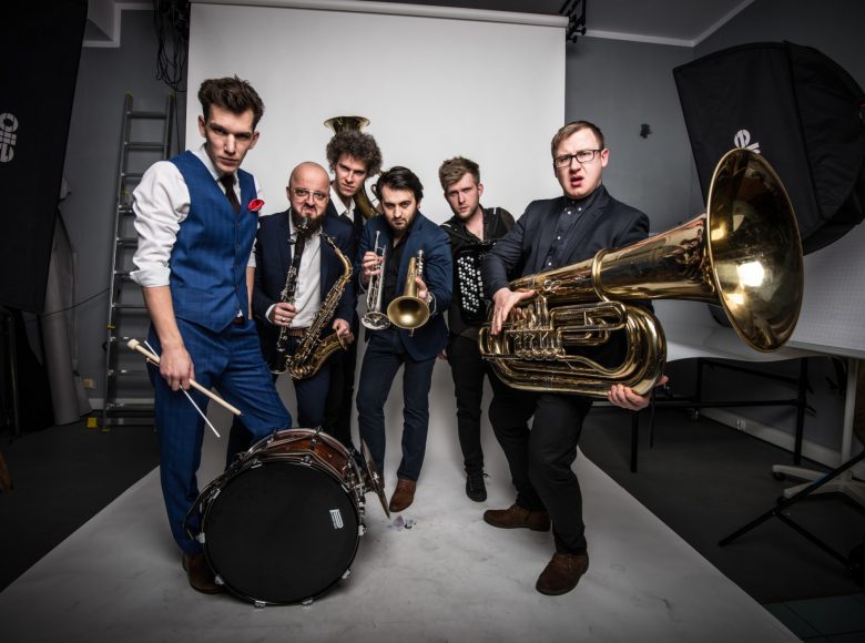 Sześciu mężczyzn. Członkowie zespołu Bum Bum Orkestar. Są na planie zdjęciowym. Mają przy sobie instrumenty.