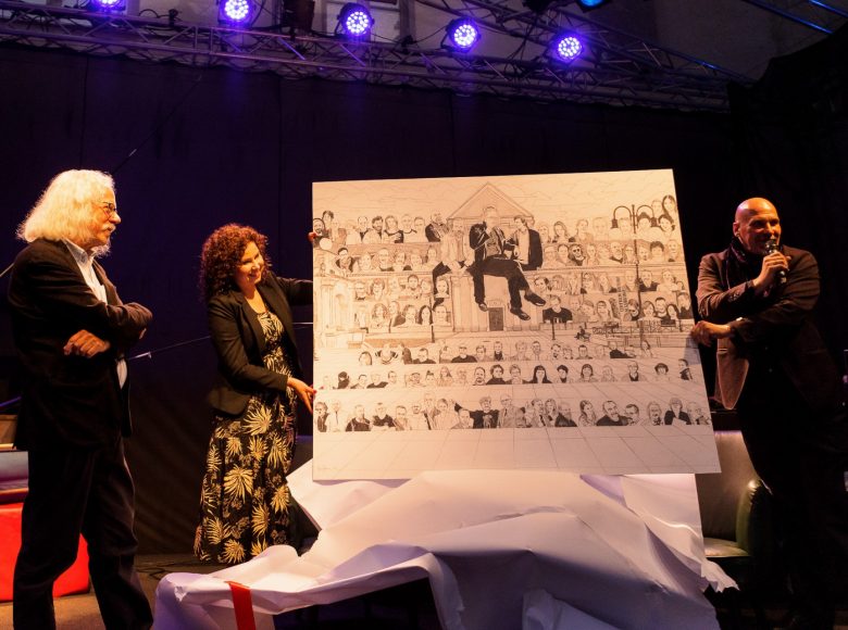 Zdjęcie. Elegancko ubrani kobieta i mężczyzna prezentują trzeciej osobie obraz. Obraz przedstawia pracowników Centrum Kultury w Lublinie.