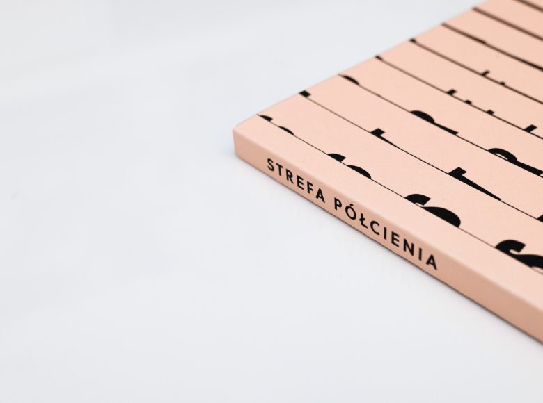 Zdjęcie. Róg okładki książki. Na grzbiecie tytuł czarnymi, drukowanymi literami: STREFA PÓŁCIENIA.