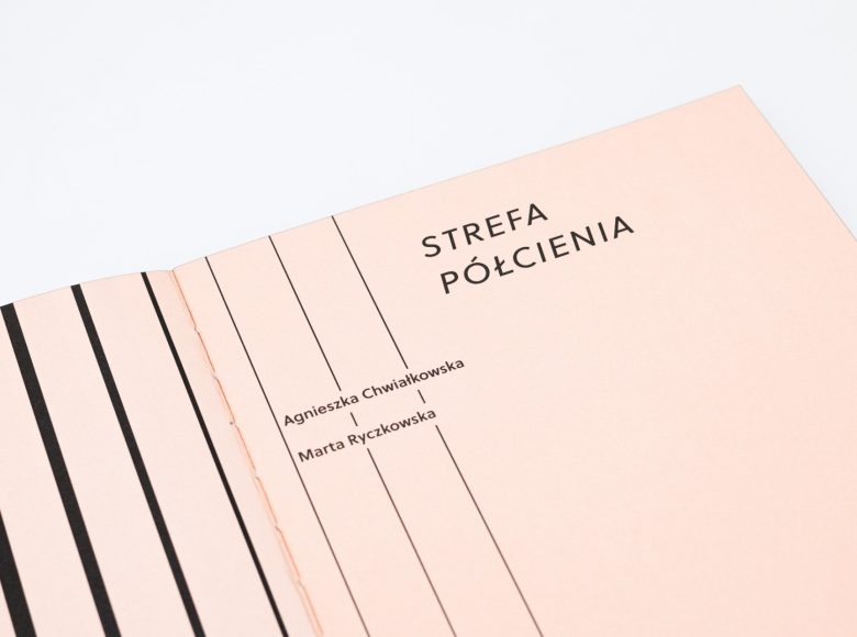 Zdjęcie. Zbliżenie na otwartą książkę. Strony są w kolorze kremowym, przecinają je pionowe, czarne pasy, różnej grubości. Tytuł publikacji : Strefa Półcienia, autorstwo: Agnieszka Chwiałkowska, Marta Ryczkowska.