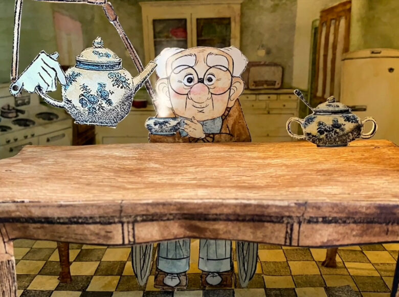 Kadr z filmu animowanego. Kuchnia, kuchenny stół, za nim sympatyczny, starszy pan na wóżku inwalidzkim. Mechaniczna ręka trzyma imbryk, staruszek trzyma filiżankę z której unosi się para.