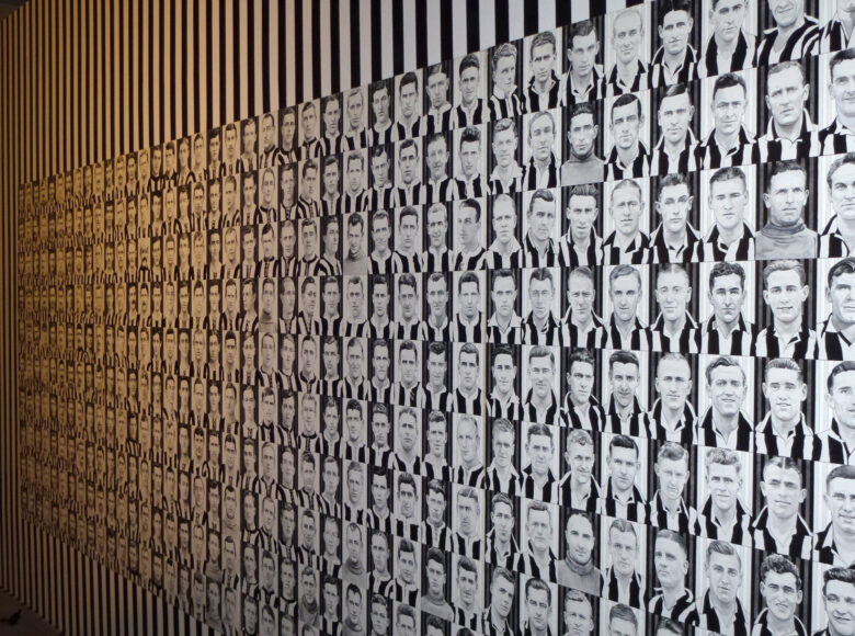 Grafika na ścianie. Składa się z namalowanych setek małych popiersi piłkarzy grupy Niukasl Junajted, którzy mają koszulki w biało-czarne pionowe pasy.