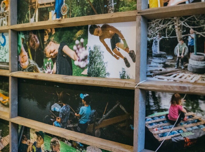 Zdjęcie. Na zbliżeniu drewniane ramki, w których znajduja się zdjęcia dzieci podczas zajęć i zabawy w Rezerwacie Dzikich Dzieci.