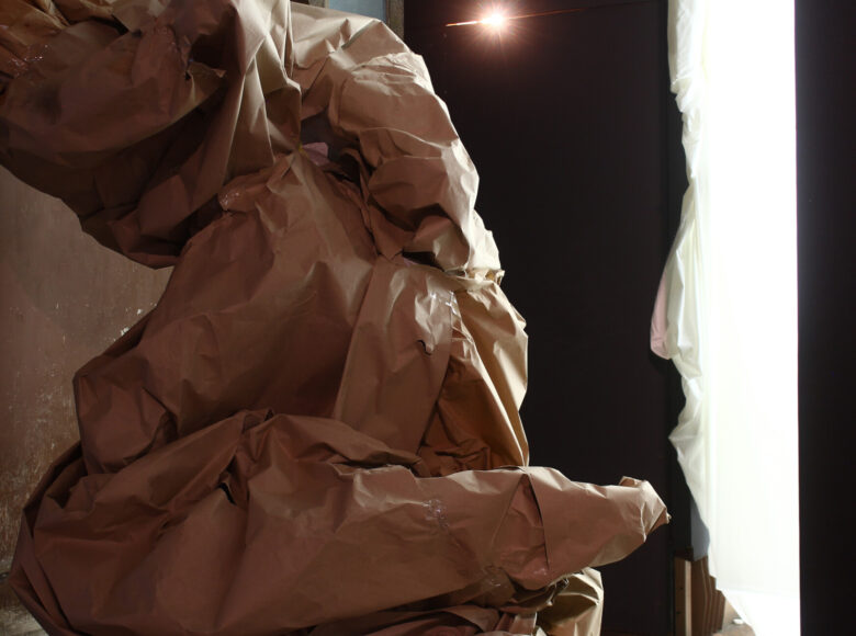 Zdjęcie przedstawia wnętrze galerii sztuki. Konstrukcja na pierwszym palnie ma nieregularne kształty, jest wykonana z papieru pakowego.