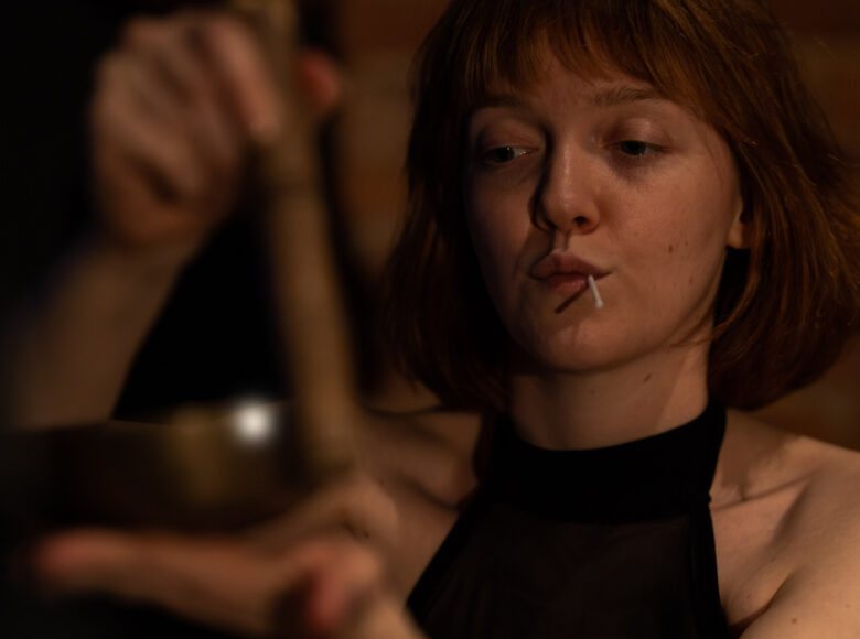 Zdjęcie przedstawia młoda kobietę, która ma w ustach lizaka.