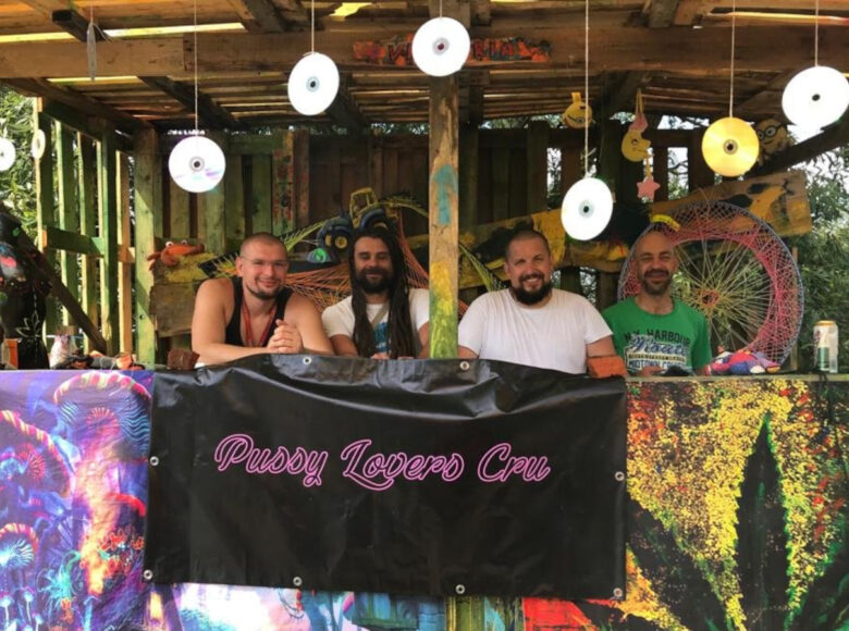 Zdjęcie przedstawia czterech mężczyzn, którzy znajdują się w domku na drzewie. Z drewnianego sufitu zwisają, zawieszone na cienkich sznurkach płyty CD. Na jednej ze ścian domku powieszone są kolorowe banery z konopiami.