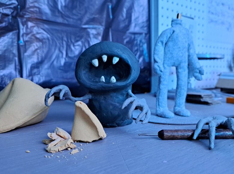 Kadr z filmu animowanego. Stworek o wielkiej zębatej paszczy stoi nad pokruszonym ciastkiem z wróżbą.