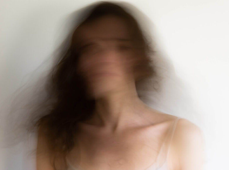 Kolorowa fotografia. Rozmazane zdjęcie twarzy kobiety. Kobieta ma rozpuszczone włosy.