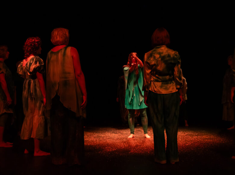 Kobiety stoją w okręgu i patrzą na osobę, która znajduje się w środku.