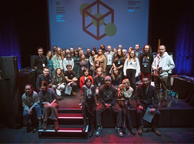 Na scenie stoi i siedzi kilkadziesiąt osób, wszyscy mają identyfikatory Lubelskiego Festiwalu Filmowego, kilka osób trzyma dyplomy i statuetki Złotego Mrówkojada.