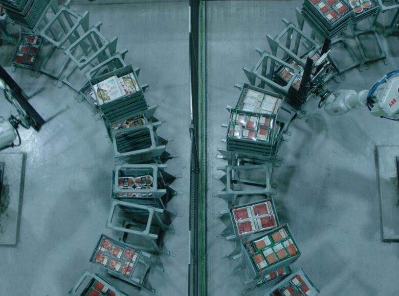 Fotografia przedstawia fabrykę i maszyny, które wykonują prace. Jest podzielona na dwie części, symetryczne, niczym lustrzane odbicie. Utrzymana w zimnym, fabrycznym kolorze zieleni.