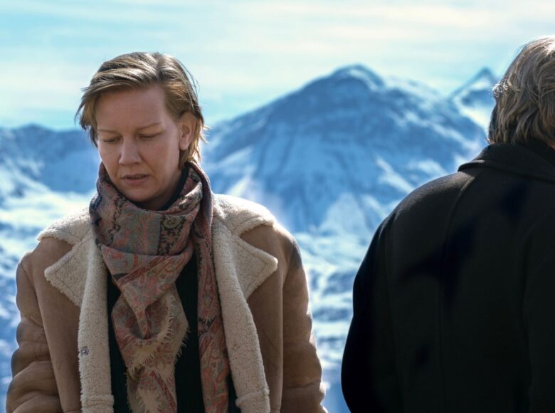 Kobieta i mężczyzna na tle zimowej scenerii gór. Stoją odwróceni od siebie, nie widzimy twarzy mężczyzny.