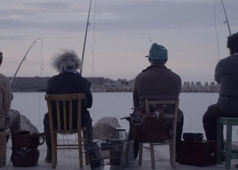 Kadr z filmu. Czterech mężczyzn siedzi na krzesłach na przystani. Mężczyźni łowią ryby.