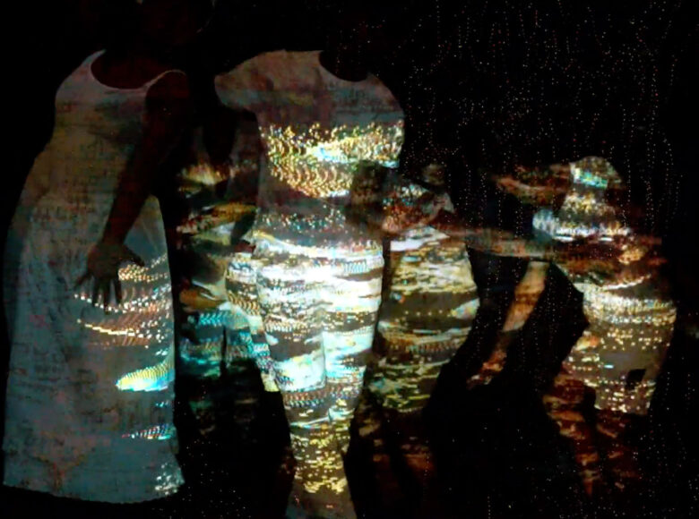 Zdjęcie przedstawia grupę tańczących w kręgu osób.