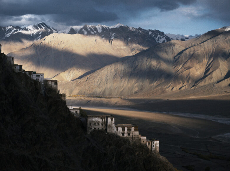 Widok na skaliste góry. Na jednym ze wzgórz widać domy.