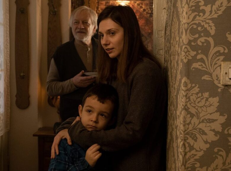 Wnętrze mieszkania. W przedpokoju stoi starszy mężczyzna i młoda kobieta tuląca małego chłopca.