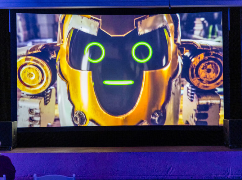 Na zdjęciu ekran filmowy. Na ekranie wyświetlony kadr, przedstawiający abstrakcyjną kompozycję.