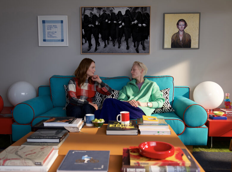 Dwie kobiety siedzą na sofie w kolorowym, nowoczesnym pokoju wypoczynkowym.