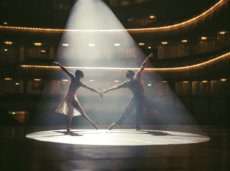 Na scenie tancerka i tancerz w baletowych pozach.