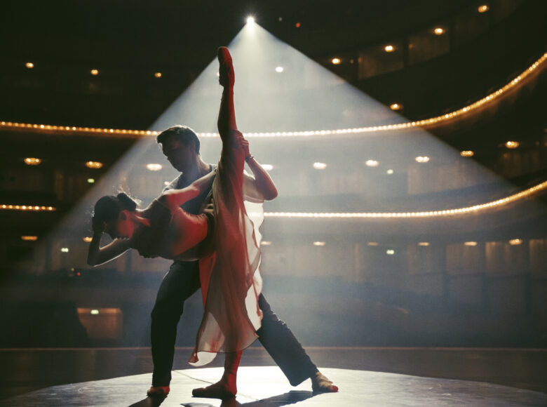 Na scenie tancerka i tancerz w baletowych pozach.