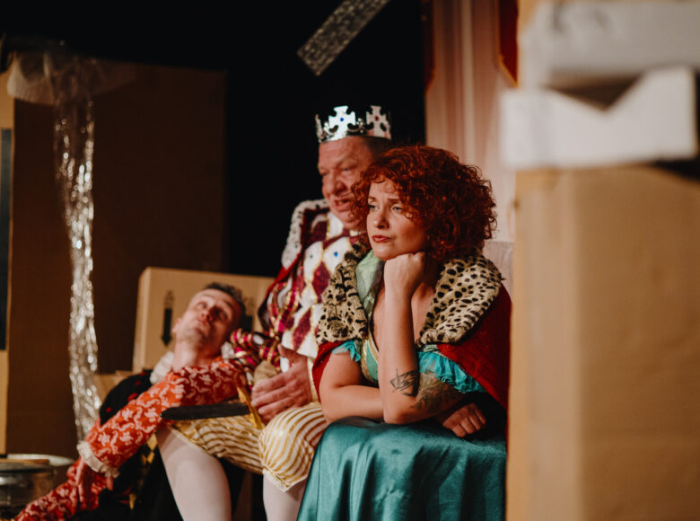 Spektakl teatralny. Na scenie kobieta i dwóch mężczyzn w bajkowych kostiumach.