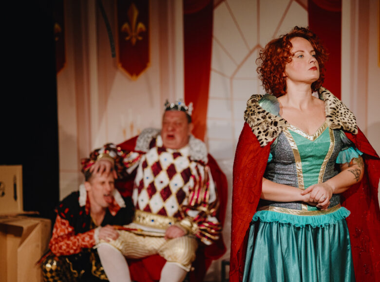 Spektakl teatralny. Na scenie kobieta i dwóch mężczyzn w bajkowych kostiumach.