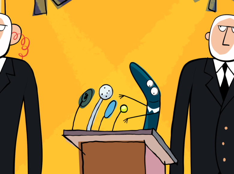 Kadr z filmu rysunkowego. Na trybunie przemawiająca skarpetka w kolorze niebieskim. Po jej dwóch stronach stoją dwaj ochroniarze w czarnych garniturach. Z tyłu żółte tło.