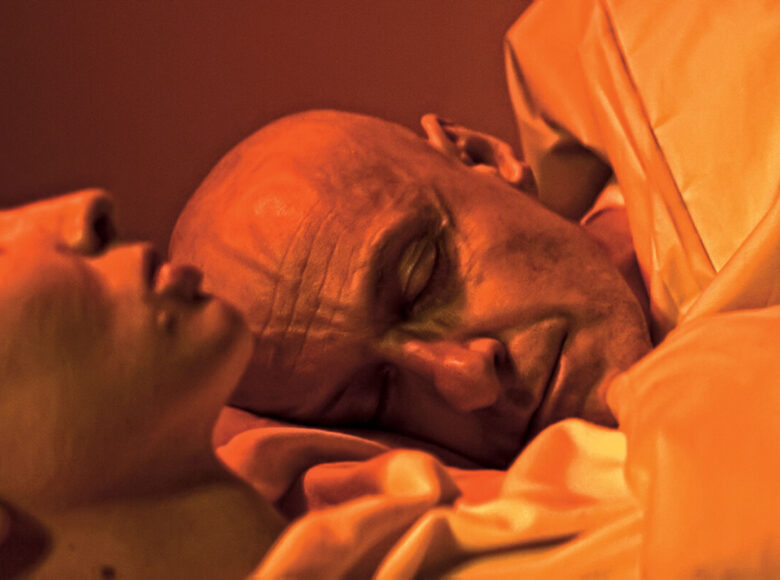 W łóżku śpią kobieta i mężczyzna. Oboje są łysi.