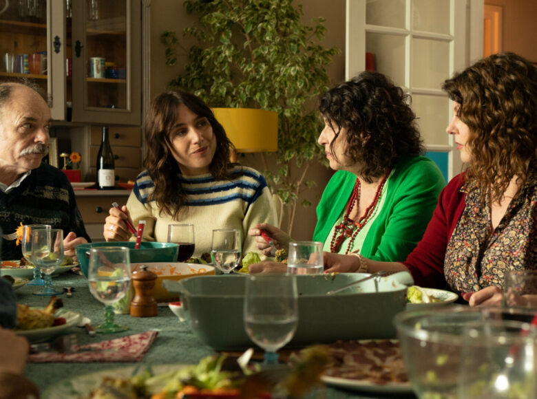 Kadr z filmu. Jadalnia w domu. Wokół suto zastawionego stołu siedzi kilka kobiet i mężczyzna. Jedzą posiłek i rozmawiają.