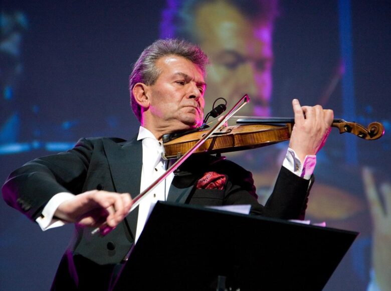 Na scenie muzyk grający na skrzypcach.