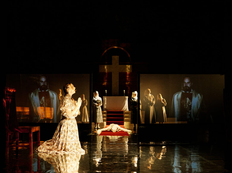 Spektakl teatralny. W scenografii przedstawiającej wnętrze kościoła grupa aktorek i aktor, odgrywający mszę.