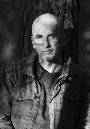 Fotograficzny, czarno-biały portret mężczyzny w średnim wieku.