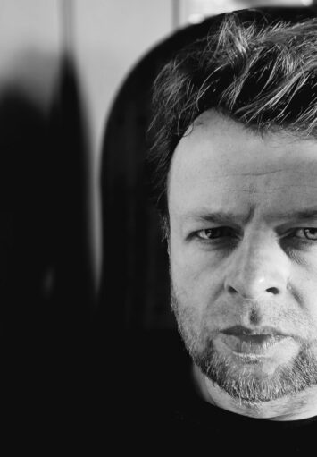 Fotograficzny czarno-biały portret mężczyzny w średnim wieku.