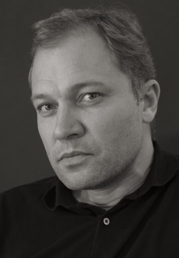 Fotograficzny czarno-biały portret mężczyzny w średnim wieku.