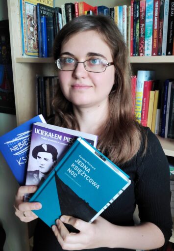 Fotograficzny portret młodej kobiety, trzymającej w rękach kilka książek.