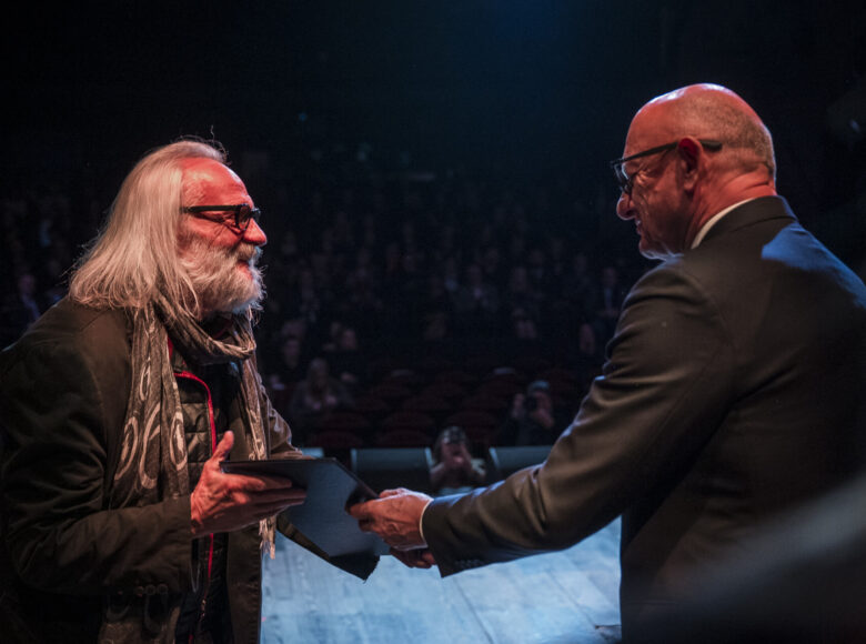 Uroczystość na scenie. Janusz Opryński, reżyser teatralny otrzymuje dyplom od prezydenta Lublina.