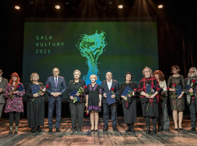 Na scenie stoi w rzędzie grupa elegancko ubranych osób. Za nimi w tle napis "Gala Kultury dwa tysiące dwadzieścia pięć".