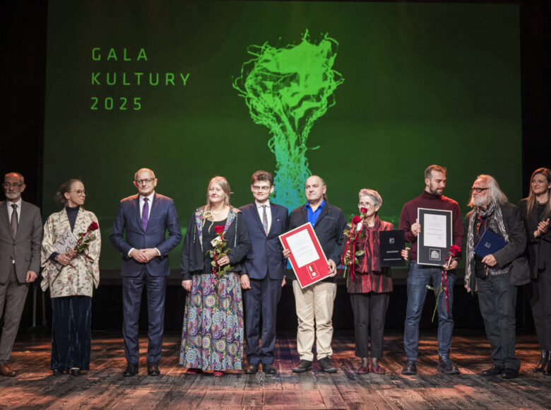 Na scenie stoi w rzędzie grupa elegancko ubranych osób. Za nimi w tle napis "Gala Kultury dwa tysiące dwadzieścia pięć".