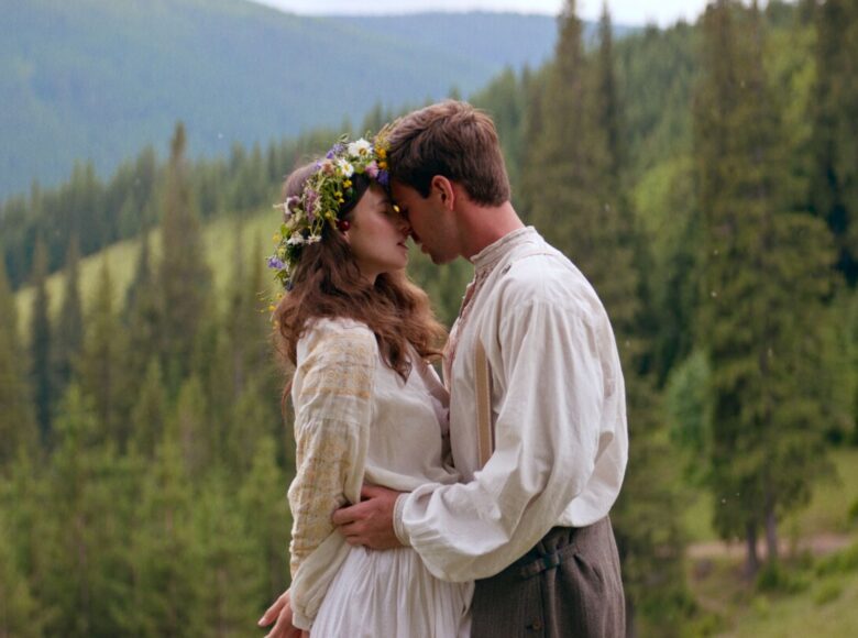 Pogodny dzień. Na tle zielonych, zalesionych wzgórz stoi dziewczyna z chłopakiem, obejmując się i całując. Ubrani są w wiejskie, odświętne stroje. Dziewczyna ma białą sukienkę, a na głowie wianek z polnych kwiatów.
