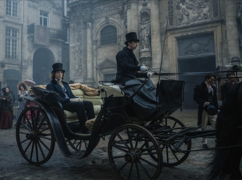 Kadr z filmu. Akcja dzieje się w dziewiętnastym wieku. Miejską ulicą, w dorożce jedzie młody, elegancko ubrany mężczyzna. Dookoła widać kamienice i spacerujących ludzi.