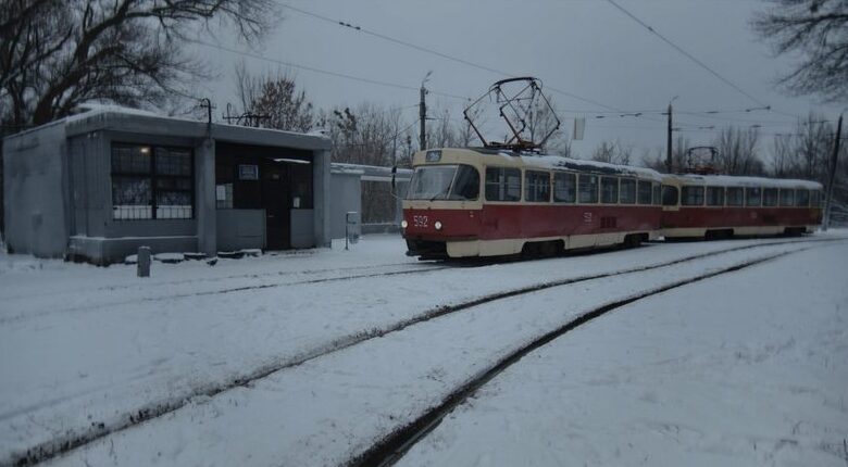 Kadr z filmu. Pochmurny, zimowy dzień. Tramwaj podjeżdża na przystanek tramwajowy. Na ziemi śnieg, dookoła drzewa.