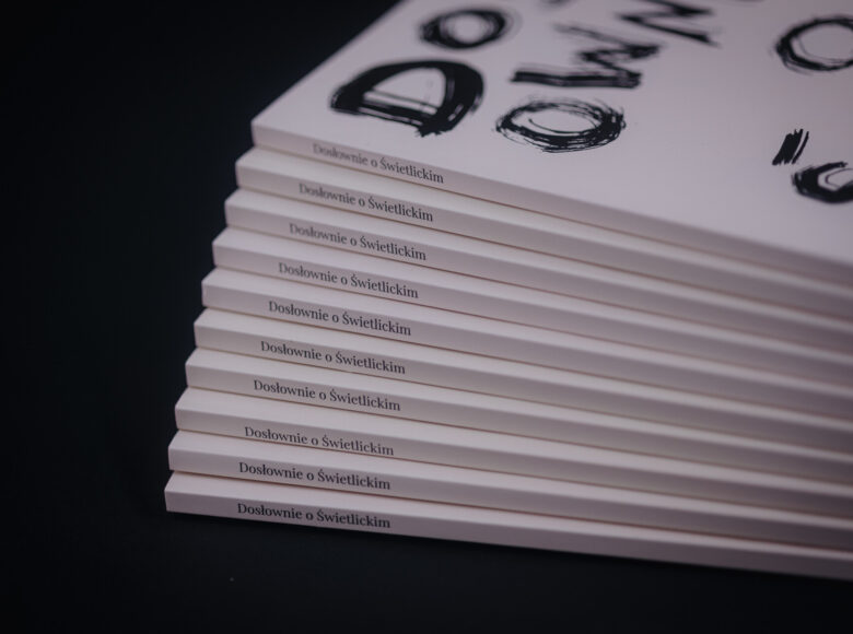 Zbliżenie na kilka egzemplarzy książki pt. "Dosłownie o Świetlickim". Egzemplarze leżą ułożone jeden na drugim.