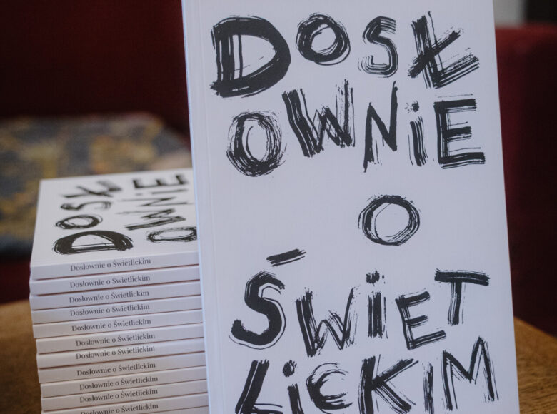 Zbliżenie na kilka egzemplarzy książki pod tytułem "Dosłownie o Świetlickim". Jeden z egzemplarzy stoi oparty o pozostałe, ułożone jeden na drugim.